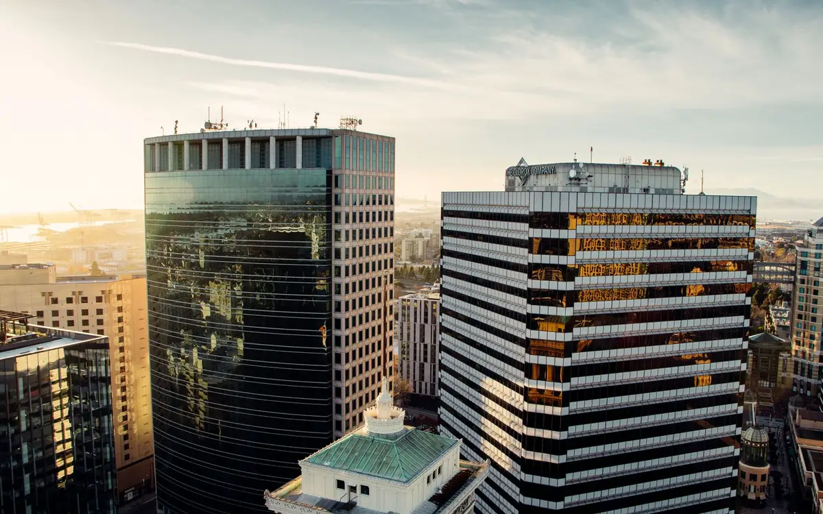 Aerial view of a cluster of office buildings at sunrise, the kind of multi-site portfolio a facilities firm maintains
