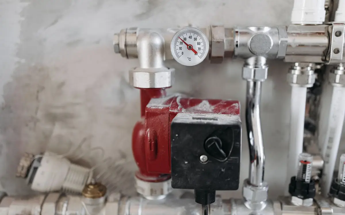 Steel pipework and a pressure gauge in a building plant room